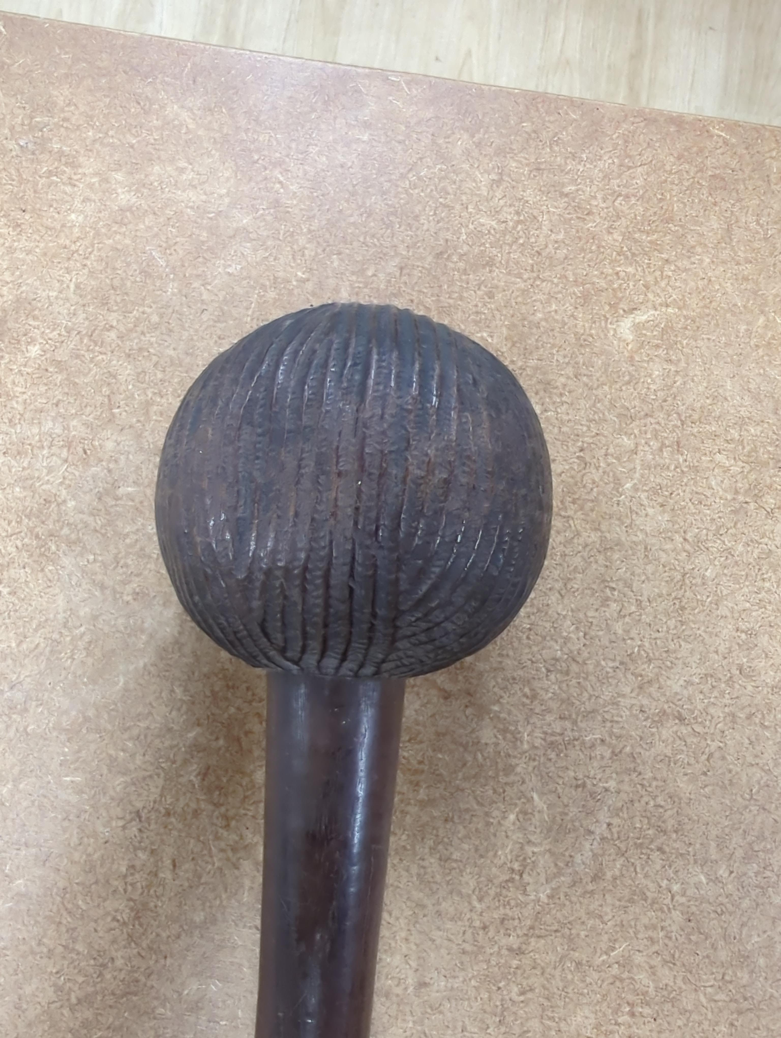 A tribal mask, a Knobkerrie and stick with carved head, stick 62.5cm